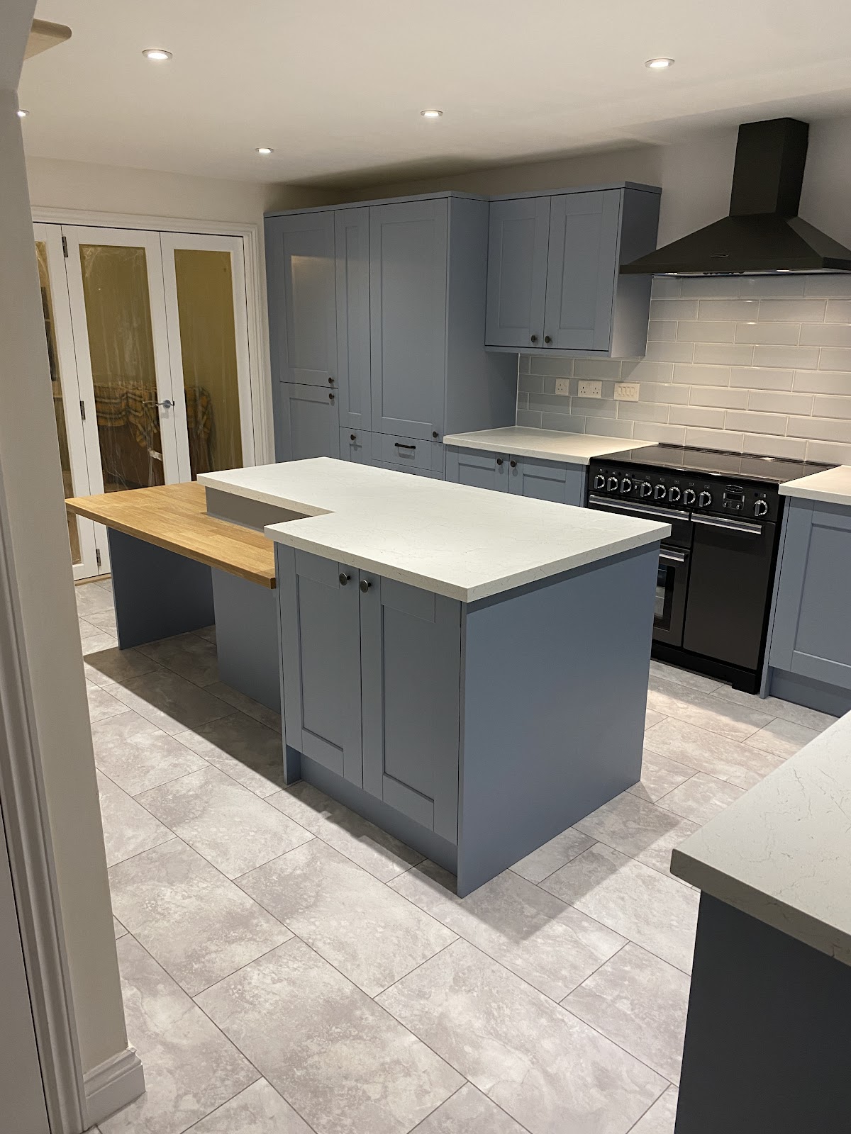 Blue-grey shaker kitchen with an oak breakfast bar