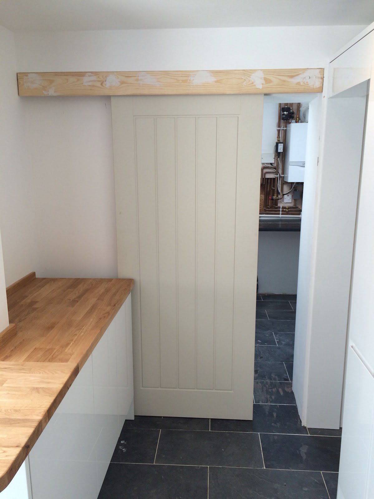 Utility room with a bespoke sliding shaker door and oak worktop