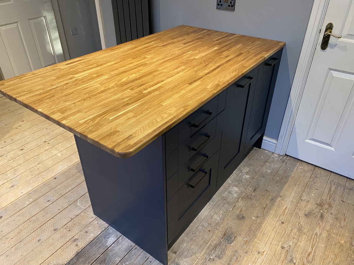 Navy kitchen island with a solid butcher-block oak top